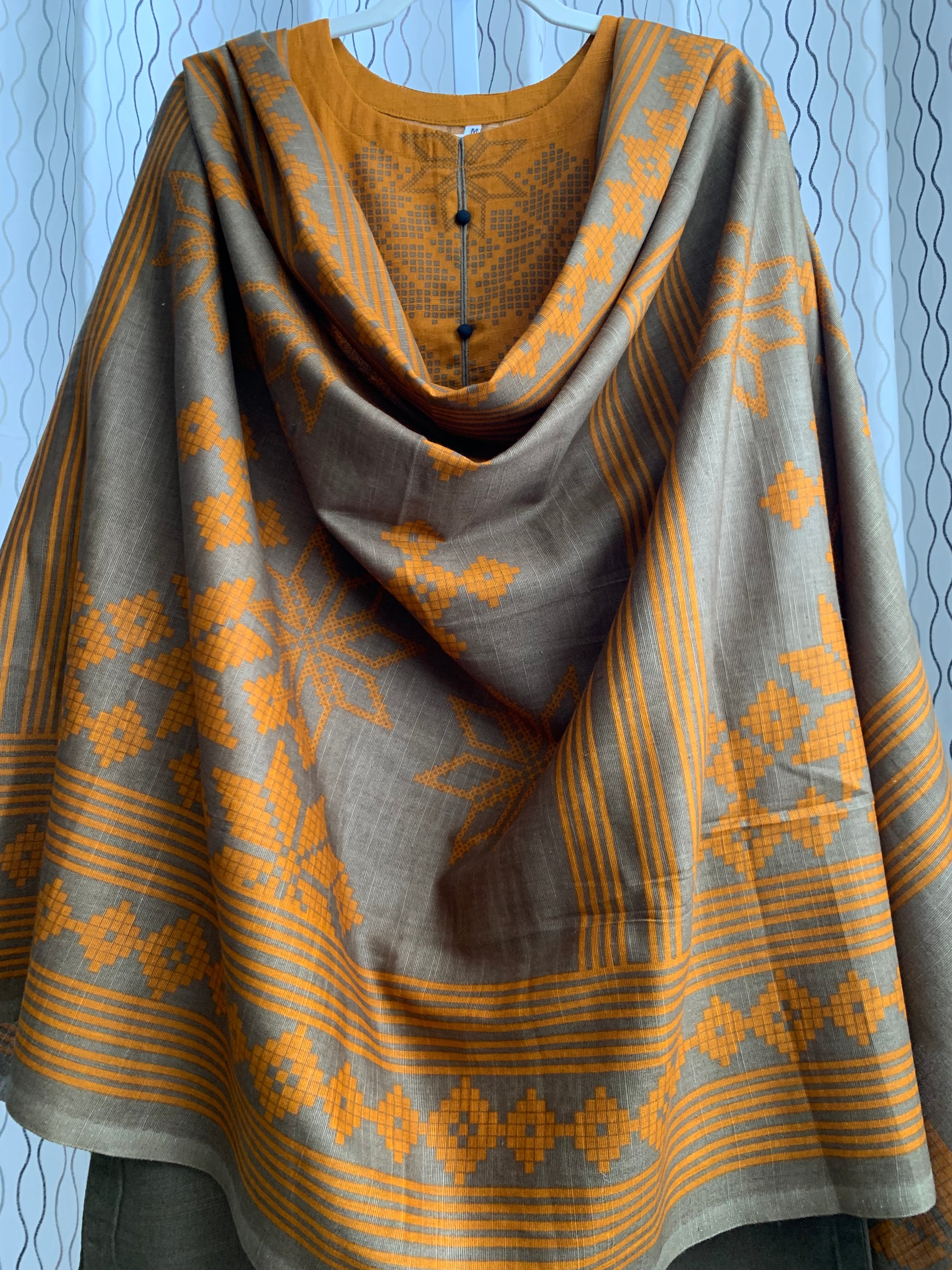 Modest Khaddar Suit for Women:  it offers a Modest Relax Fit Style along with Custom Stitch. Crafted with Exotic Khaddar Fabric, which is a blend of Organic Cotton and Wool Slub. This 3 piece suit includes one Tunic, matching Trouser and a full Shawl, perfect for the winter season. Available in Bronze & Green color, S-M-L-XL  sizes, and guarantees both comfort and elegance.