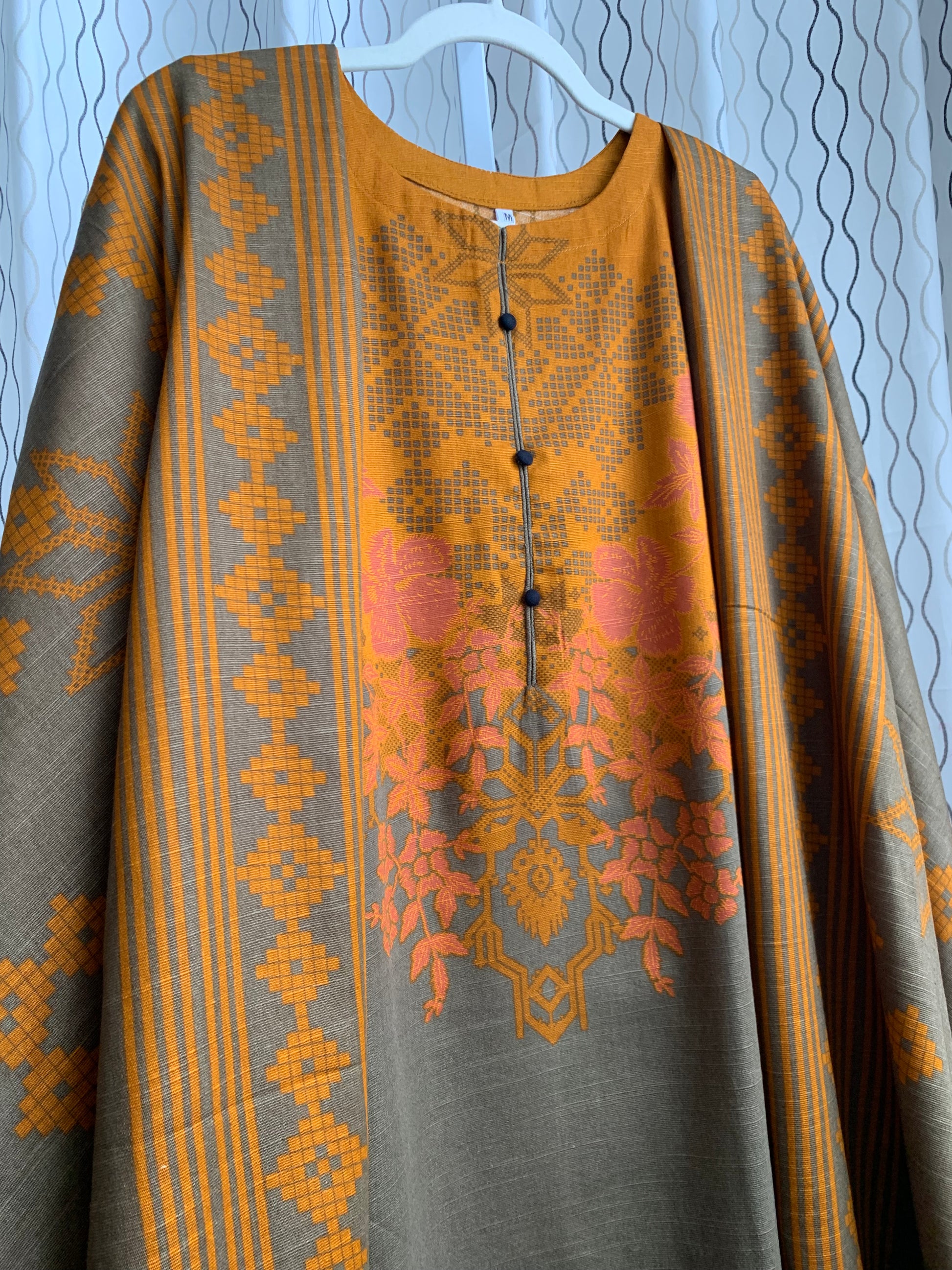 Modest Khaddar Suit for Women:  it offers a Modest Relax Fit Style along with Custom Stitch. Crafted with Exotic Khaddar Fabric, which is a blend of Organic Cotton and Wool Slub. This 3 piece suit includes one Tunic, matching Trouser and a full Shawl, perfect for the winter season. Available in Bronze & Green color, S-M-L-XL  sizes, and guarantees both comfort and elegance.